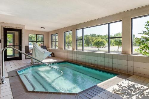a hot tub in a room with windows at Comfort Suites Grandville - Grand Rapids SW in Grandville