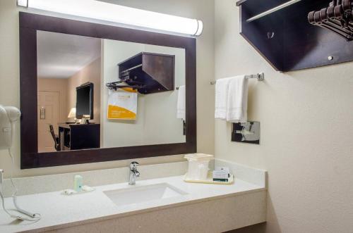 a bathroom with a sink and a large mirror at Quality Inn McComb in McComb