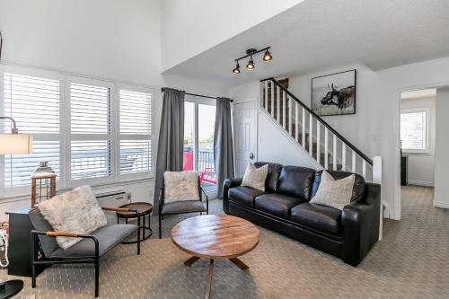 een woonkamer met een zwarte leren bank en stoelen bij Mountain Peaks Ski-In-Out Pool Shuttle in Blue Mountains