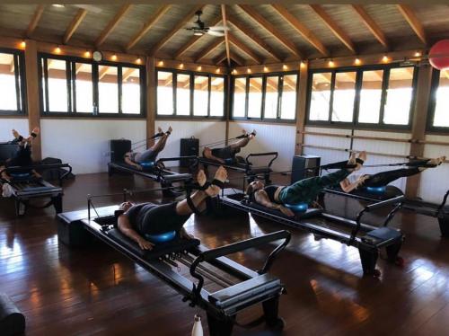 Un grupo de personas haciendo flexiones en un gimnasio. en Pilates Nosara, en Playa Guiones