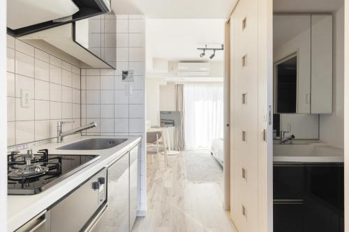a white kitchen with a sink and a tub at Dash Living Ryogoku in Tokyo