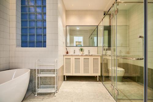 un bagno con vasca, lavandino e specchio di Villa Mystery Saigon ad Ho Chi Minh