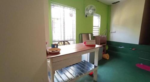 an office with a desk in a room with green walls at SPOT ON 90119 Bed's Guesthouse in Kuching