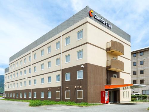 a hotel building with a sign on top of it at Comfort Inn Kofu Isawa in Fuefuki