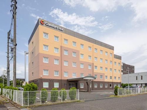 a brown building with a sign on the top of it at Comfort Inn Niigata Chuo Inter in Niigata