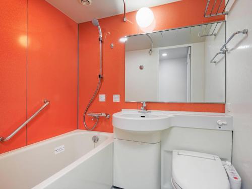 um banheiro com uma pia, um vaso sanitário e um espelho em Comfort Inn Kofu Isawa em Fuefuki