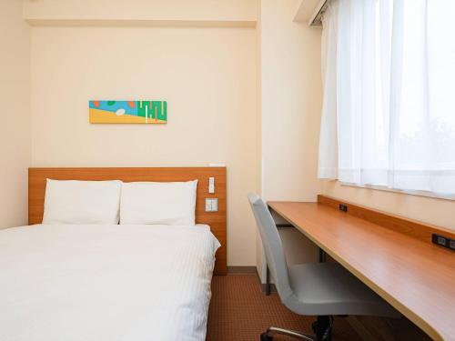a hotel room with a bed and a desk at Comfort Inn Niigata Chuo Inter in Niigata