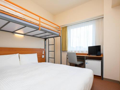 a hotel room with a bed and a desk with a computer at Comfort Inn Niigata Chuo Inter in Niigata