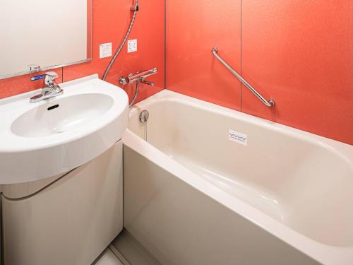 ひたちなか市にあるコンフォートインひたちなかの洗面台と浴槽のあるバスルーム