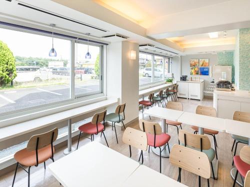 a dining room with tables and chairs and a window at Comfort Inn Hitachinaka in Hitachinaka
