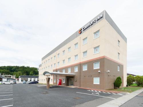 a large building with a parking lot in front of it at Comfort Inn Ichinoseki Inter in Ichinoseki