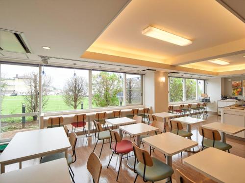a classroom with tables and chairs and windows at Comfort Inn Ichinoseki Inter in Ichinoseki