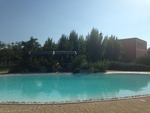a large pool of blue water in a yard at Tenuta Monaci La Murra in Carmiano