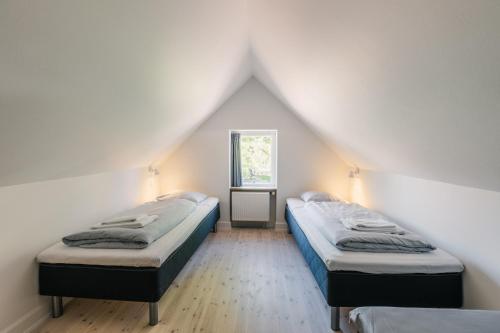 リーベにあるRibe Byferie Resortの白い壁の部屋にベッドが2つある