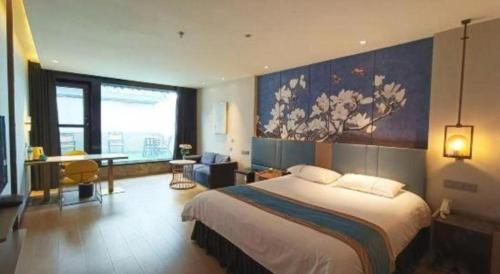 a bedroom with a large bed and a large painting on the wall at Magnotel Shenyang Consulate Qingnian Street in Shenyang