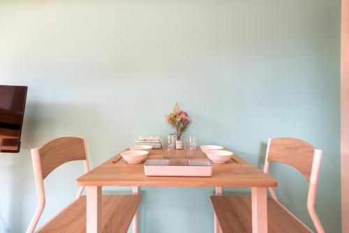 a wooden table with two chairs and a laptop on it at minpaku Blanco大須 in Nagoya