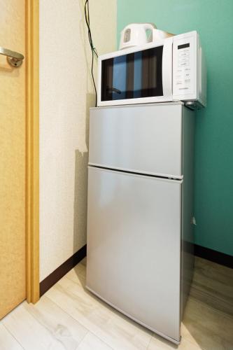 a microwave sitting on top of a refrigerator at minpaku Blanco大須 in Nagoya