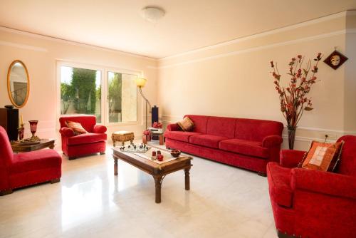 a living room with red couches and a coffee table at Villa Kokalis Resort hotel in Gouves