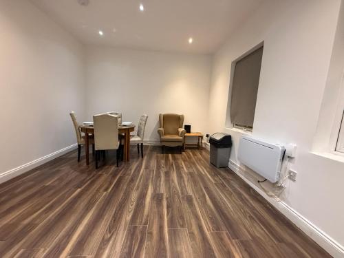 a dining room with a table and chairs and a large screen at Belin Stay in Hackbridge