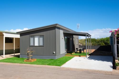 uma pequena casa ao lado de uma rua em Sunset Beach Holiday Park em Geraldton