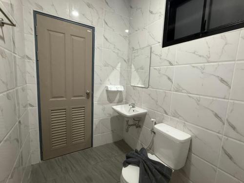 a white bathroom with a toilet and a sink at Soft Blue Home, Krabi Town in Krabi