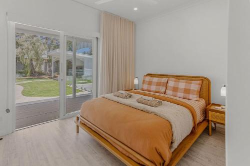 Coastal Waters - Spa, Sleeps 8, Newly Renovated في أوشن غروف: غرفة نوم بها سرير ونافذة كبيرة