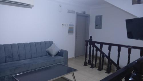 a living room with a couch and a tv at Private Rooms And Bed Spaces Available In Sohar in Al ‘Awhī
