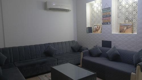 a living room with two couches and a table at Private Rooms And Bed Spaces Available In Sohar in Al ‘Awhī