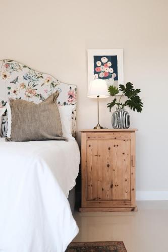 a bedroom with a bed and a lamp on a wooden cabinet at The Scottage in Howick