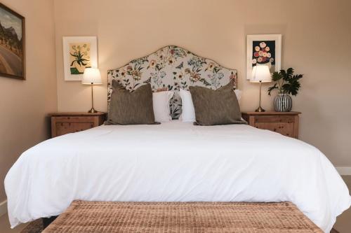 霍维克The Scottage的卧室里有一张白色的大床，床边还有两盏灯