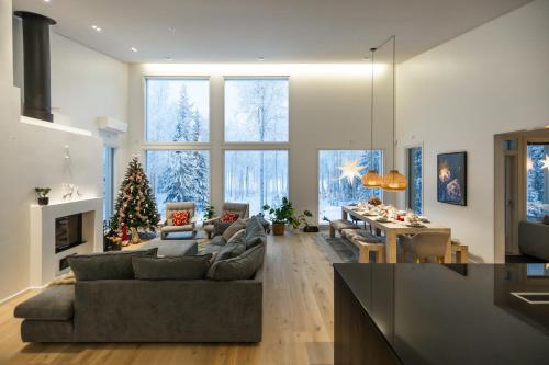 a living room with a couch and a christmas tree at Villa Lumossa - Lakeside Luxury with unique privacy in Rovaniemi