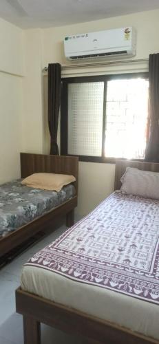 a bedroom with two beds and a window with a air conditioner at Calm Studio 6 in Jāmb