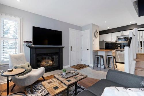 een woonkamer met een bank en een open haard bij Mountainside Escape Ski-In-Out Pool Shuttle in Blue Mountains