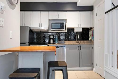 een keuken met witte kasten en een aanrecht met een magnetron bij Mountainside Escape Ski-In-Out Pool Shuttle in Blue Mountains