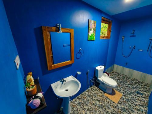 bagno blu con lavandino e servizi igienici di Bright Sun Safari a Udawalawe