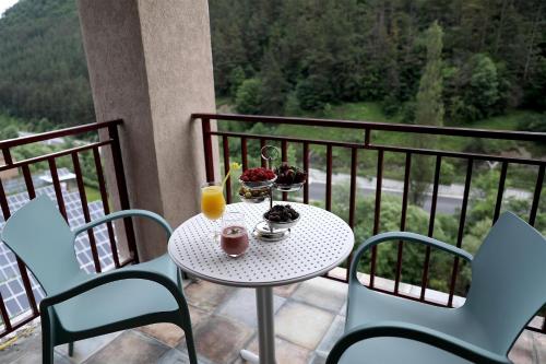 uma mesa e cadeiras numa varanda com uma bebida em Best Western Plus Paradise Hotel Dilijan em Dilijan