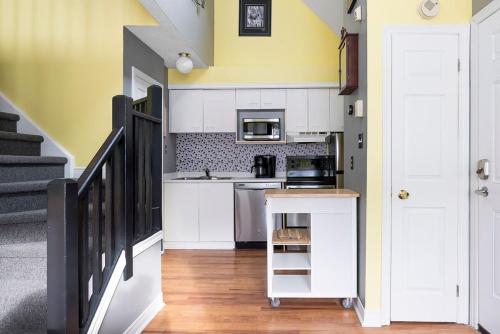 a kitchen with white cabinets and a yellow wall at Sunshine Summit Ski-In-Out Pool Shuttle in Blue Mountains