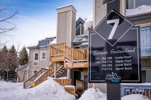 a sign in front of a house in the snow at Sunshine Summit Ski-In-Out Pool Shuttle in Blue Mountains