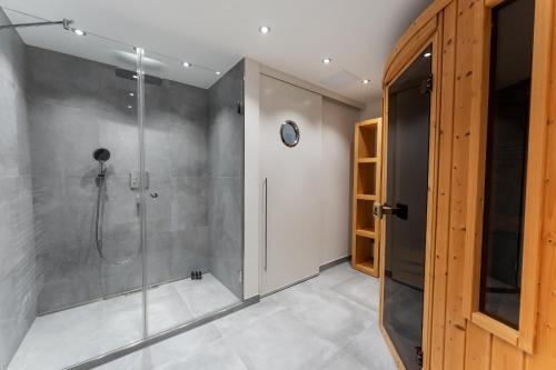 une salle de bain avec douche et porte vitrée dans l'établissement Hüs Swarte Wall, à Kampen