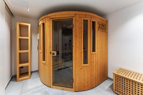 un ascenseur en bois dans une chambre avec une porte en verre dans l'établissement Hüs Swarte Wall, à Kampen