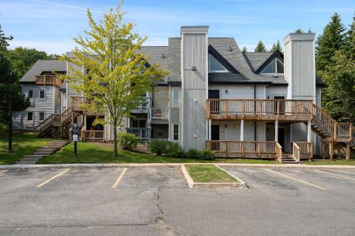 une grande maison avec un porche et un parking dans l'établissement Blue Haven Ski-In-Out Pool Hot Tub Shuttle, à Blue Mountains