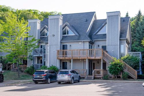 ein großes Haus mit zwei Autos davor geparkt in der Unterkunft Fox Ridge - Ski-In-Out Pool Hot Tub Shuttle in Blue Mountains