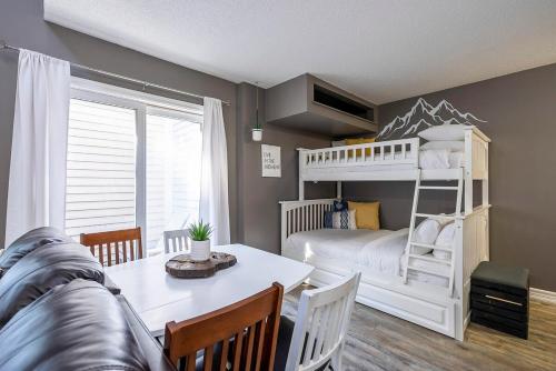 ein Schlafzimmer mit einem Etagenbett, einem Tisch und Stühlen in der Unterkunft Fox Ridge - Ski-In-Out Pool Hot Tub Shuttle in Blue Mountains