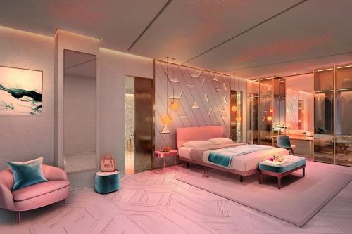 FIVE Palm Jumeirah Hotel Apartments في دبي: غرفة نوم مع سرير وردي وكرسي