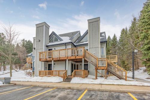 a house with a large deck on the front of it at Whispering Pines - Ski-In-Ou Pool Shuttle in Blue Mountains