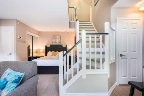 a bedroom with a bed and a staircase with a stair case at Whispering Pines - Ski-In-Ou Pool Shuttle in Blue Mountains