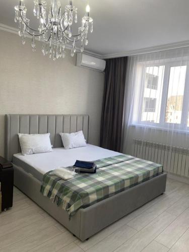 Квартира посуточно في أستانا: غرفة نوم بها سرير كبير مع ثريا