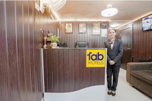 a woman standing in a room with a job horizons sign at FabHotel Komfort Inn - Nr Twin Tower in Yeraoda