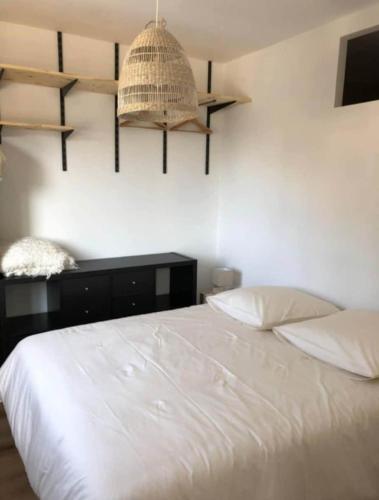 a bedroom with a white bed with two pillows at Gîte soline avec piscine chauffée in Saint-Riquier