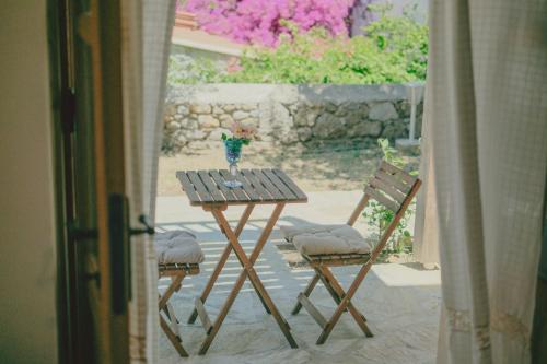 a wooden table with two chairs and a vase on it at Gulhiz in Datca